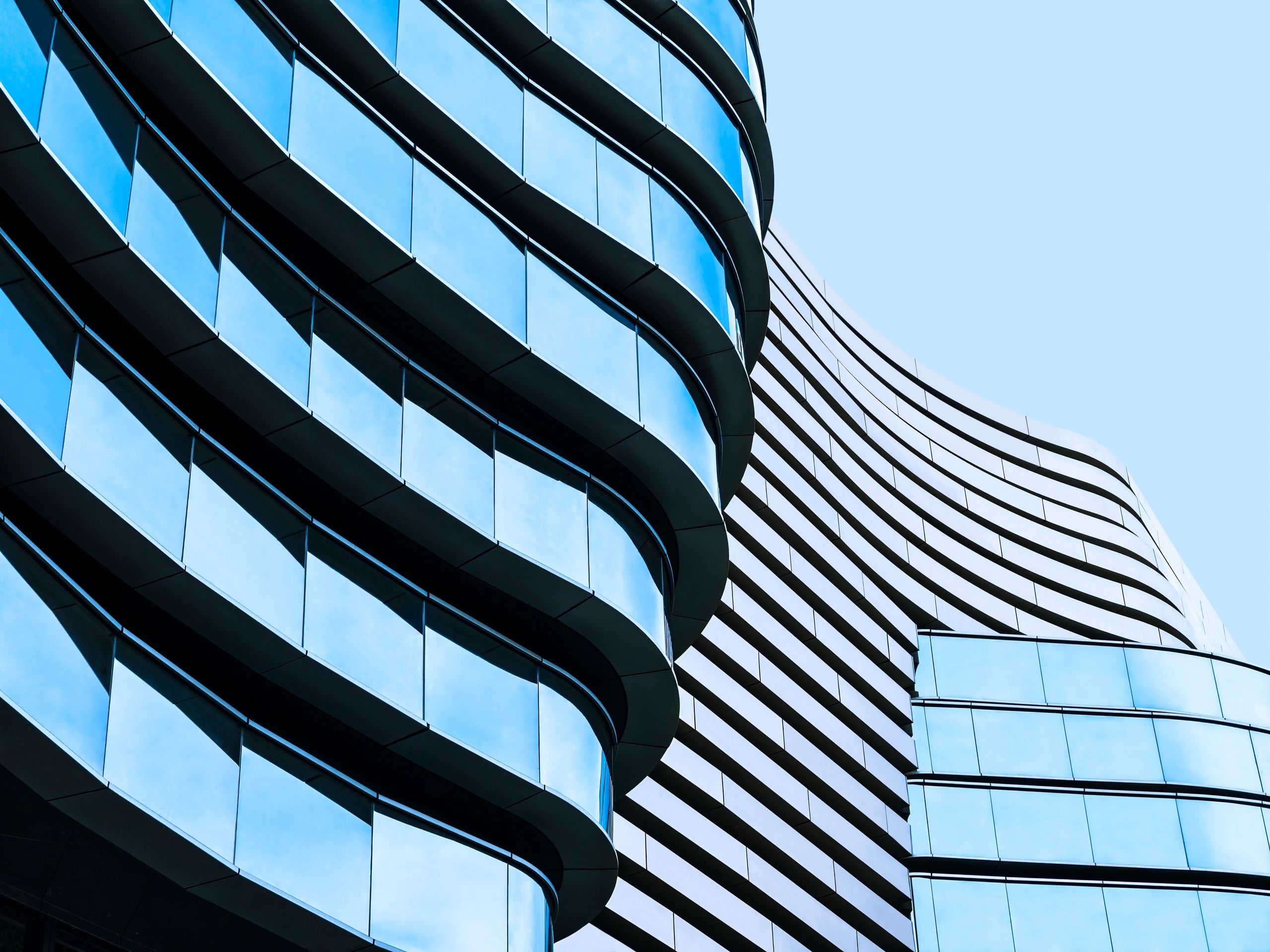 Modern glass building with curved architecture.