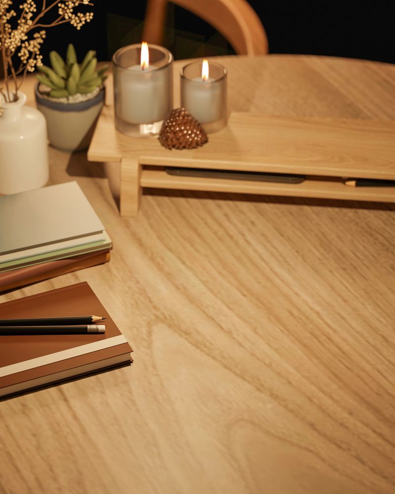 Top view of glass cup candle on wooden stand with books and flower vase on round table in warm light. Product Display, 3D Rendering, 3D illustration.