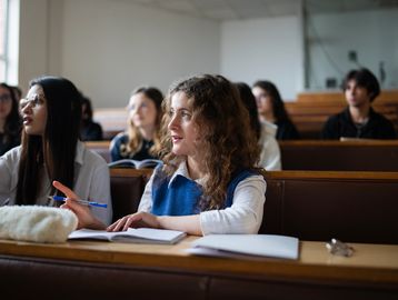 Students attentively listening in a lecture hall.