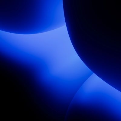 Abstract image with glowing blue shapes on a dark background.