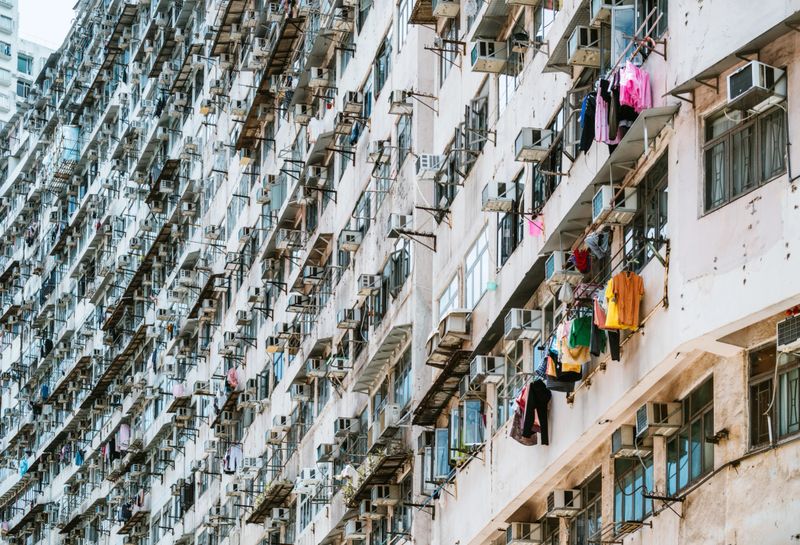 Dense high-rise housing with balcony clotheslines, reflecting crowded urban life and everyday routines in Hong Kong’s iconic residential towers.