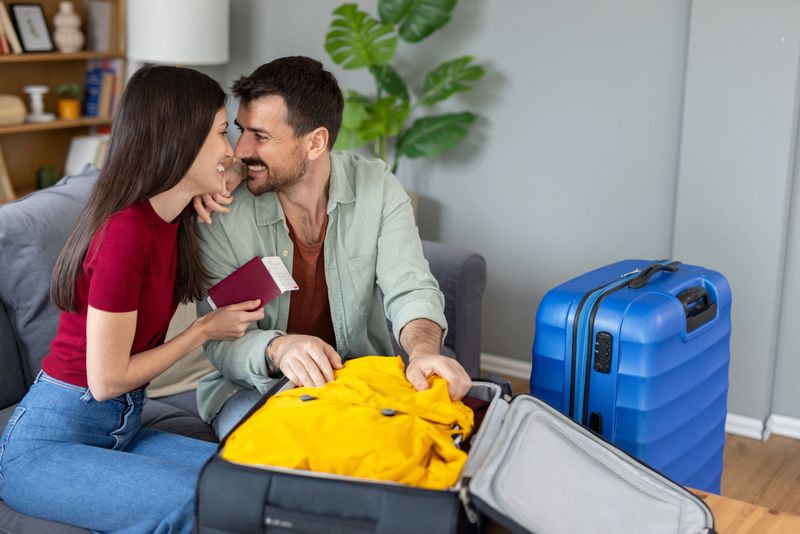 An affectionate couple is seen packing their travel gear in a cozy home setting, emphasizing warmth, unity, and anticipation for their journey.