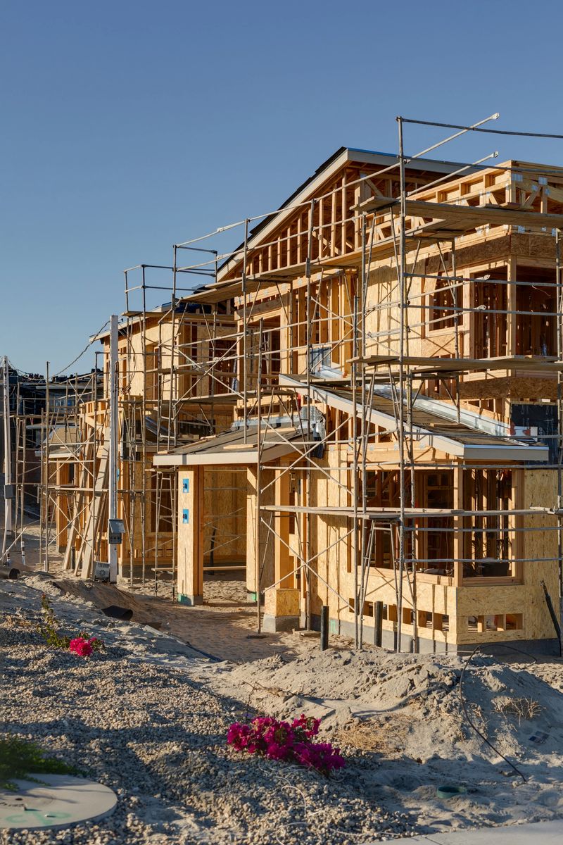 New single-family homes under construction in a suburban housing development. The image represents residential growth, real estate development, the homebuilding industry, and the housing market.