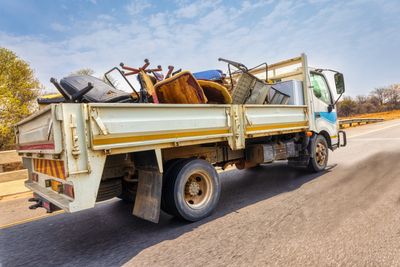 A truck loaded with old furniture and scrap items.