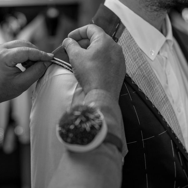 Tailor fitting a suitTailor pinning a suit jacket shoulder during a fitting at Bob Tailor Shop on a man.