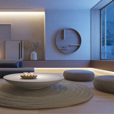 Minimalist living room with round coffee table and soft lighting.