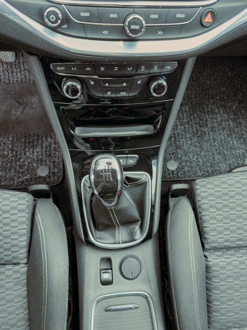 A sleek car interior reveals a well-designed gear shift and control panel, bathed in soft daylight, surrounded by comfortable seating, inviting a sense of adventure on the road ahead.