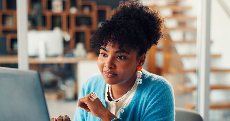 Smile, woman or laptop with research in office for manuscript revision, editing draft or feedback. Media agency, editor or tech at desk for reading submission, newsletter review or story publication