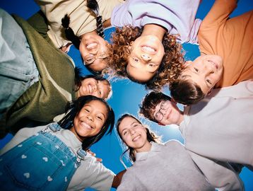 Group of diverse friends smiling in a circle.