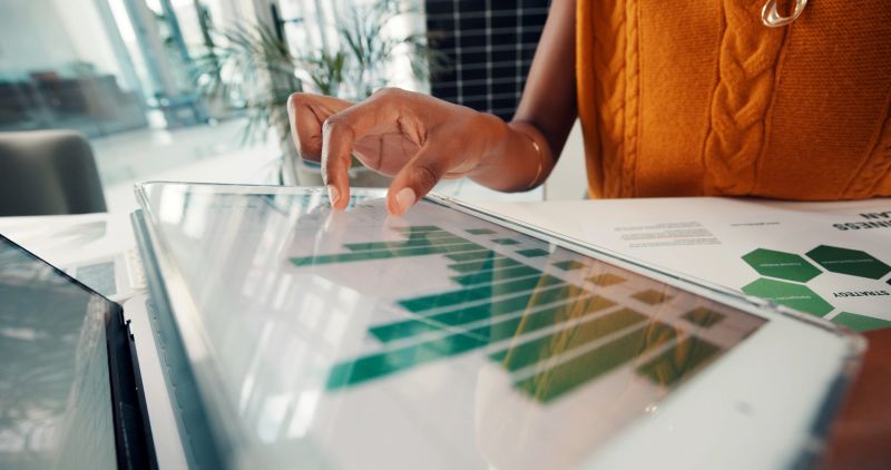 Consultor financeiro analisando dados em tablet no escritório.