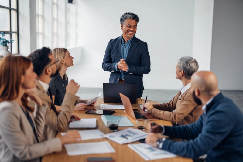 An inspirational leader addresses a group, fostering collaboration and trust while exchanging valuable insights, demonstrating effective communication in a modern workspace.