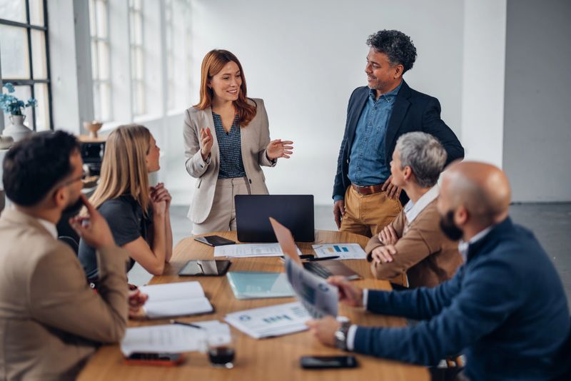 A vibrant office scene shows a team engaging in a dynamic discussion, showcasing a collaborative environment that fosters creativity and teamwork among the members.