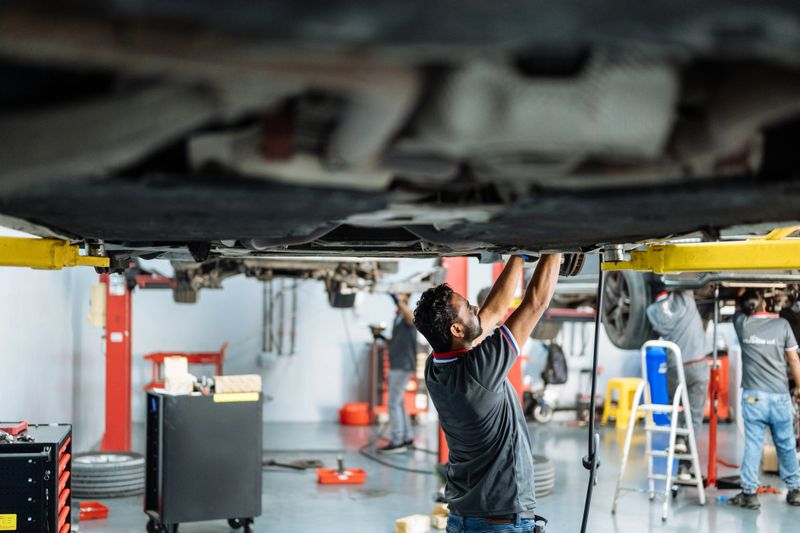 Car mechanics working in car workshop