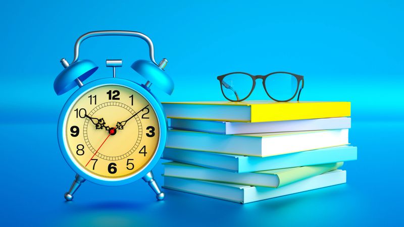 This vibrant 3D illustration features a classic blue alarm clock standing next to a neat stack of colorful books topped with black eyeglasses. Set against a seamless blue background, the composition perfectly captures the themes of education, time management, and academic preparation. The minimalist and clean design evokes a sense of focus and organization, making it ideal for back-to-school campaigns, study guides, and educational marketing materials. Perfect for students, teachers, and institutions promoting learning, reading, and exam preparation.