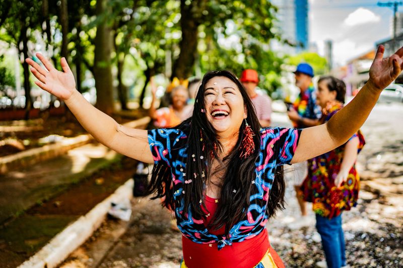Excited mature woman celebrating carnival outdoors