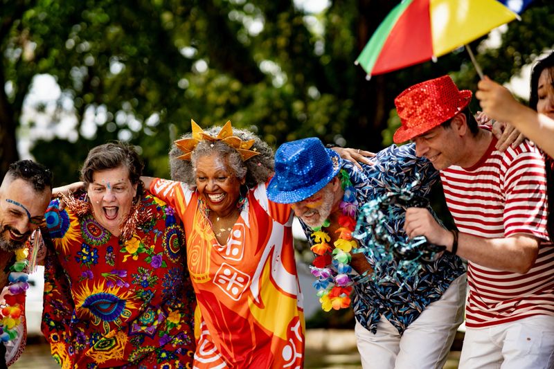 Excited friends dancing and enjoying Carnival outdoors