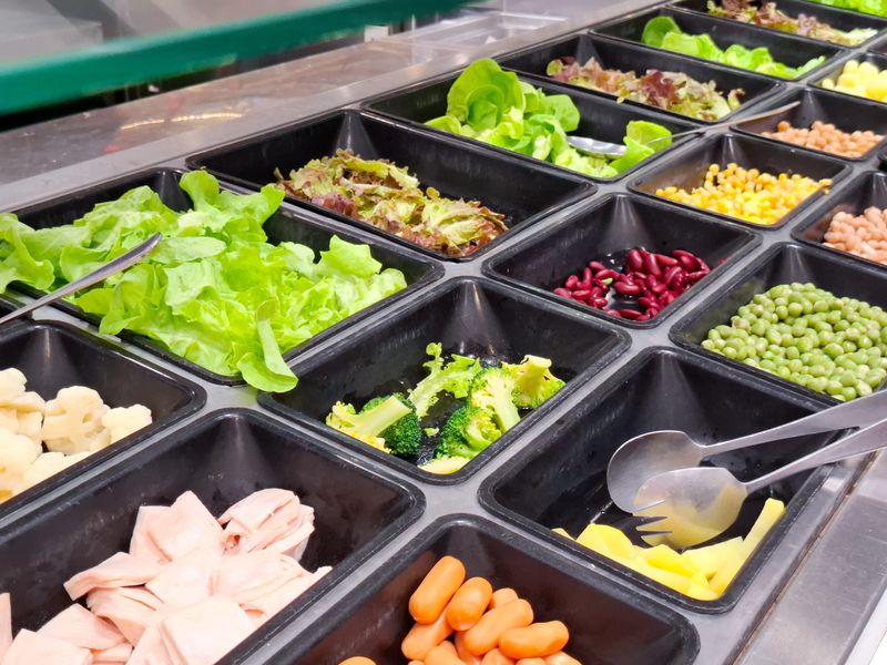 Fresh Salad Bar Selection with Variety of Healthy Vegetables and Toppings in Self Service Restaurant Buffet for Nutritious Dining Concept