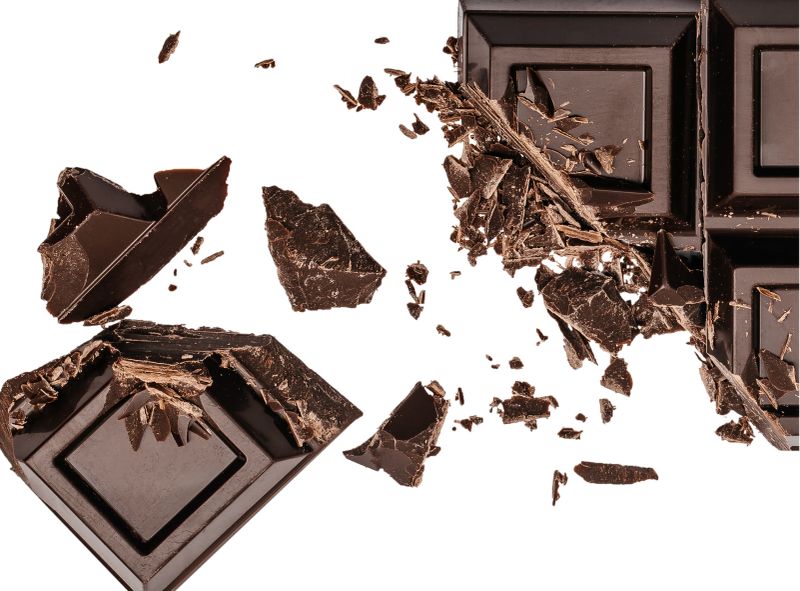 Broken dark chocolate bar with scattered chocolate shards and crumbs, isolated on white background, concept of dessert, cocoa, baking ingredients and sweet food texture