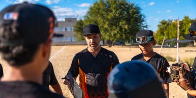 Coach giving a pep talk to a baseball team.
