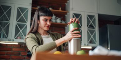 Woman making a smoothie in a kitchen.