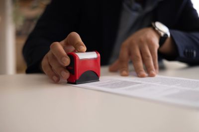 Persona colocando un sello en un documento.