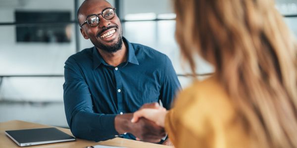 Two professionals shaking hands during a meeting.