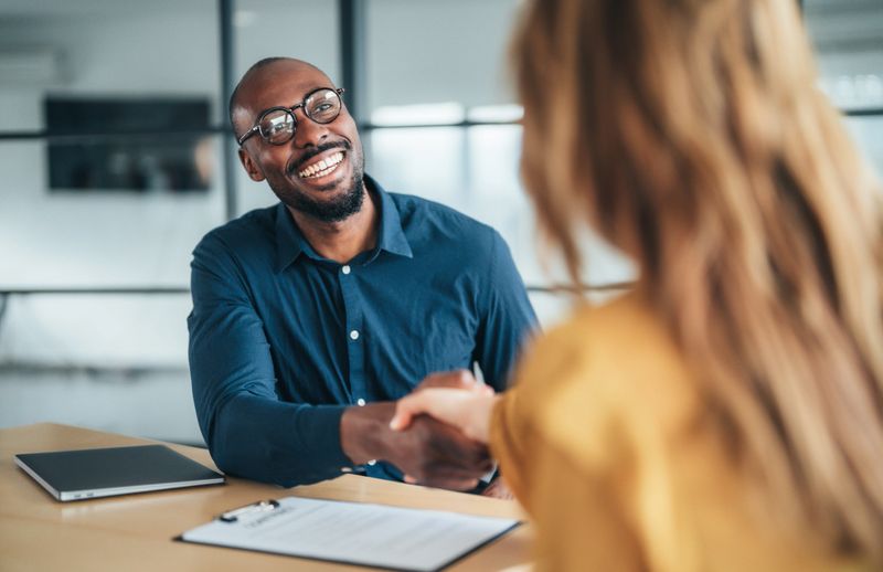 Business people shaking hands in the office. Two entrepreneurs shaking hands on job interview in board room. Corporate business team discussing new agreement. Female manager discussing new project with her colleagues. Company owner on a meeting with new employee in her office.