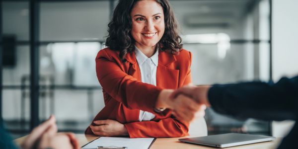Woman smiling and shaking hands.