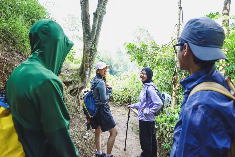 Happy Diverse Hikers Pausing On Dirt Path With Muslim Woman And Her Friend Turn Around To Check On The Rest Of The Group