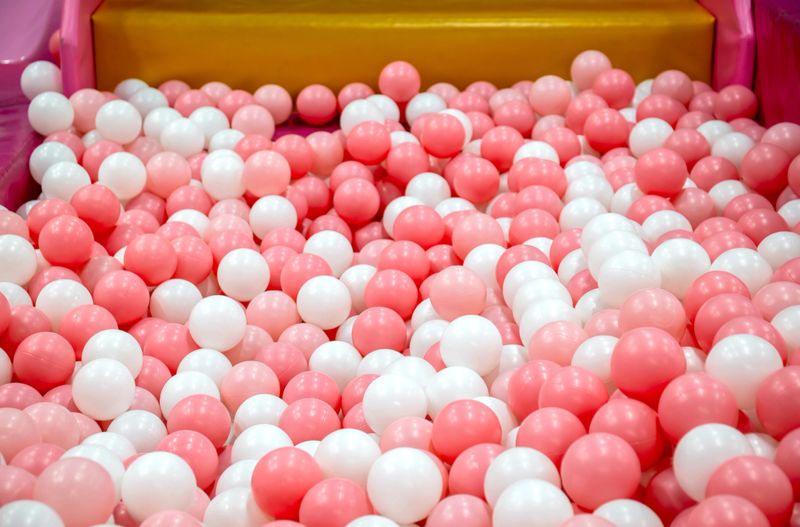 Toy ball, Pink and white play balls densely filling a ball pit, Plastic ball in a ballpit, Colorful ball in a playground, Creating a bright, Cheerful, Playful atmosphere ideal for kids themes and fun
