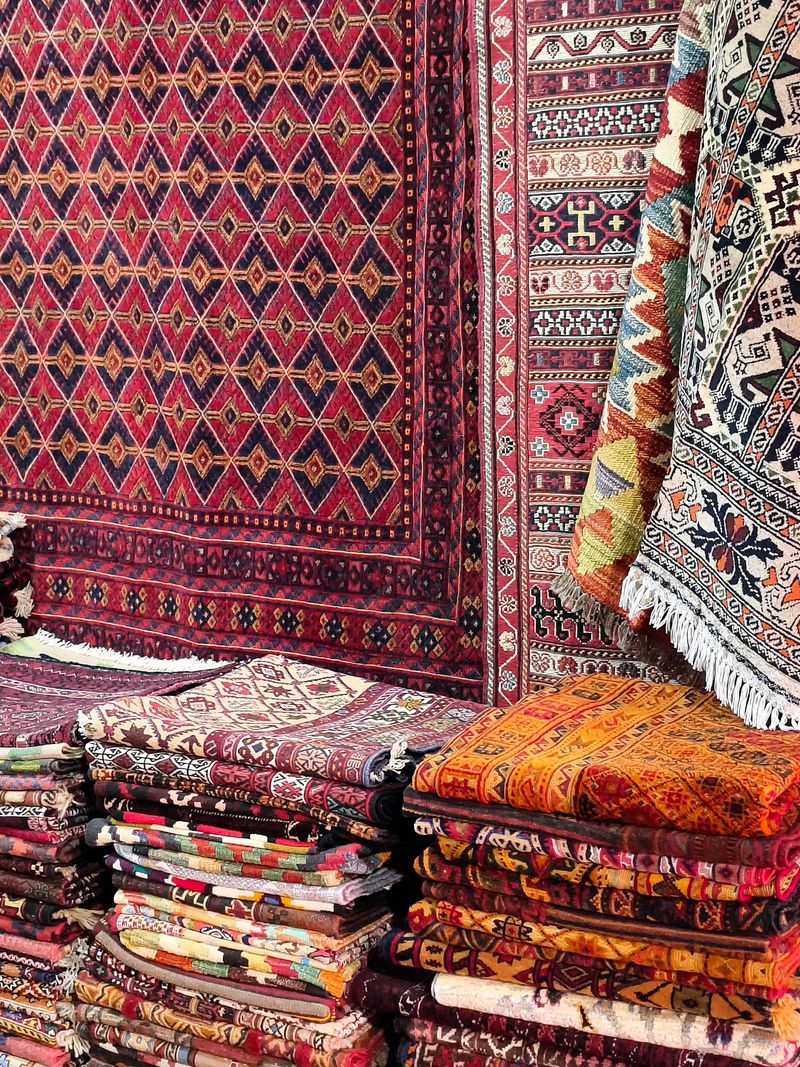 Stack of multicolored quality rugs at carpet shop, Carpets variety selection rolled up rugs shop store.