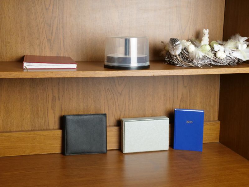 Wooden shelves with books, boxes and decorative elements in home interior