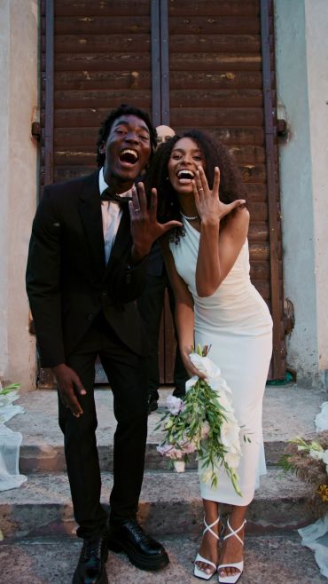 Bride and groom posing together with bouquet.