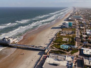 Aerial view of a coastal city with a beach and pier.