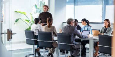 Team meeting with one standing speaker in a modern office.