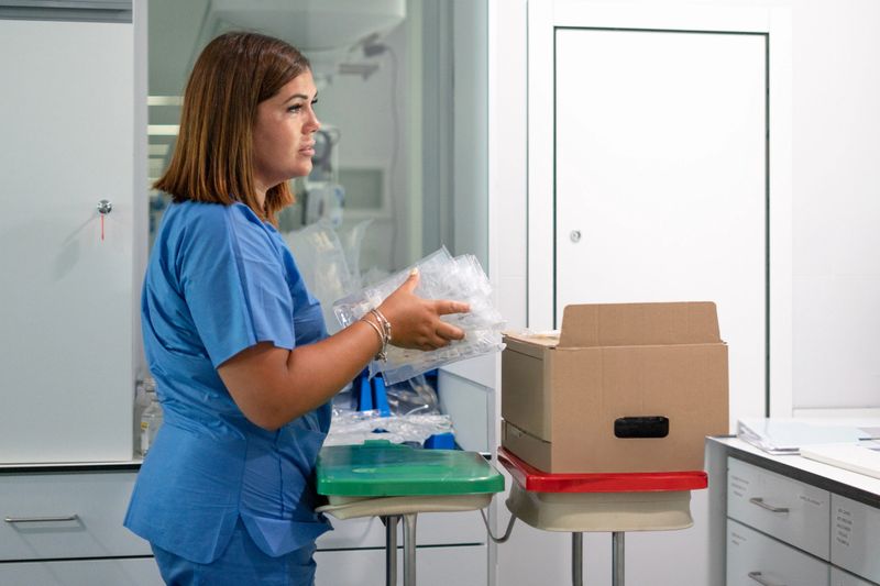 Nurse carrying plastic medical supplies while working in a clean hospital environment