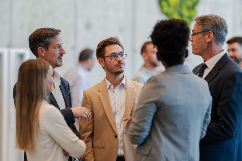 Diverse group of business people networking, communicating, and sharing ideas at a conference or corporate event