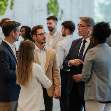 A group of diverse professionals engaged in a business conversation.