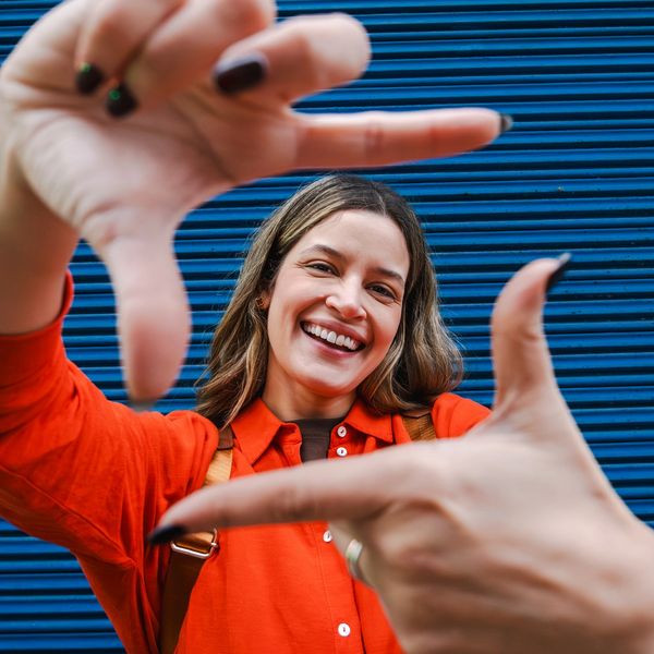 Smiling woman framing her face with hands.