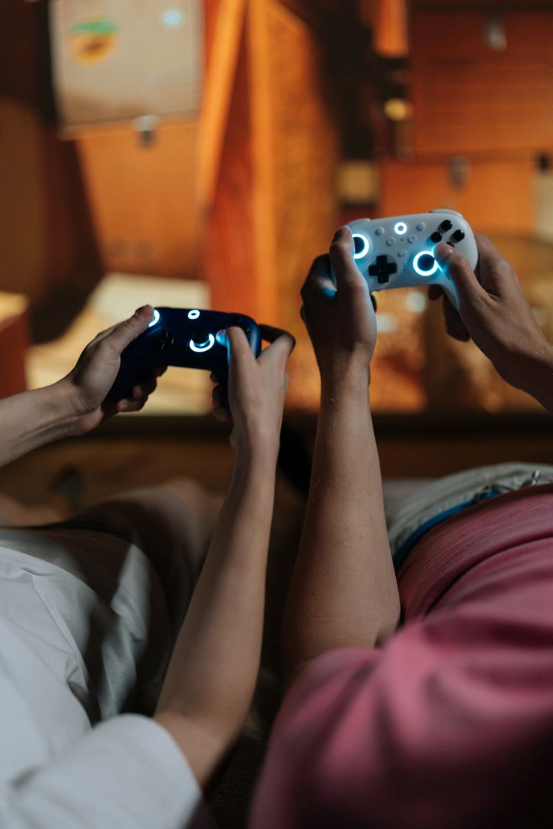 Couple holding glowing wireless controllers, immersed in virtual reality gaming on large screen at home, sharing high-tech entertainment, connection, and relaxed leisure together.