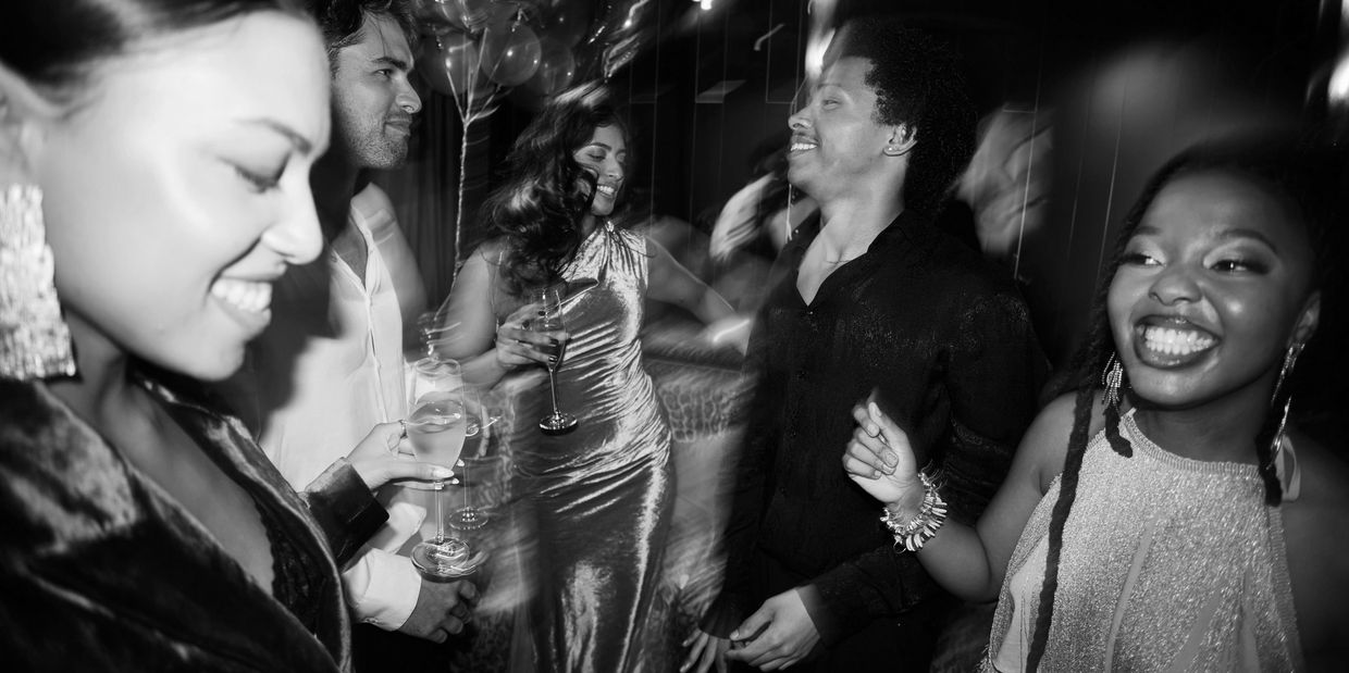 People dancing and enjoying a party in black and white.