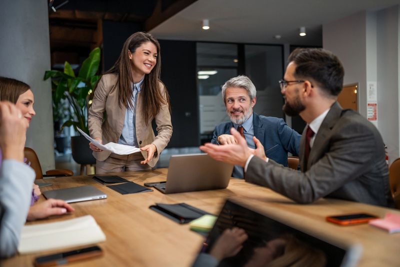 Diverse business professionals having a productive discussion and working together at a conference table in a modern corporate setting