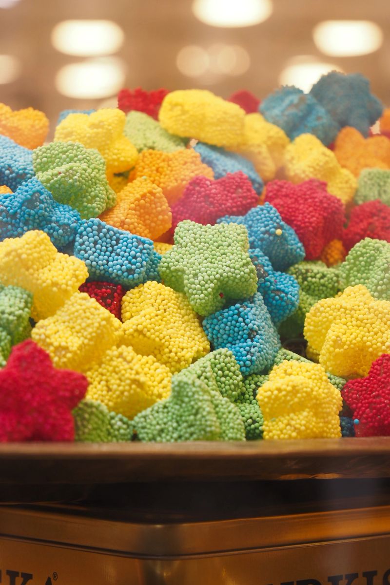 Brightly colored gummy candies are neatly arranged in a display.