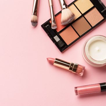 Makeup items on a pink background.