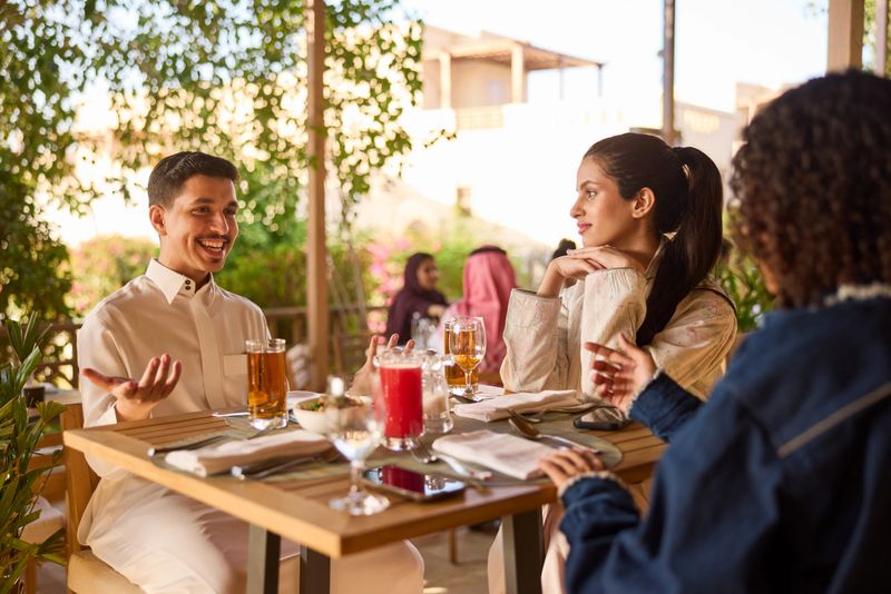 Two women and a man sit at a Middle Eastern restaurant