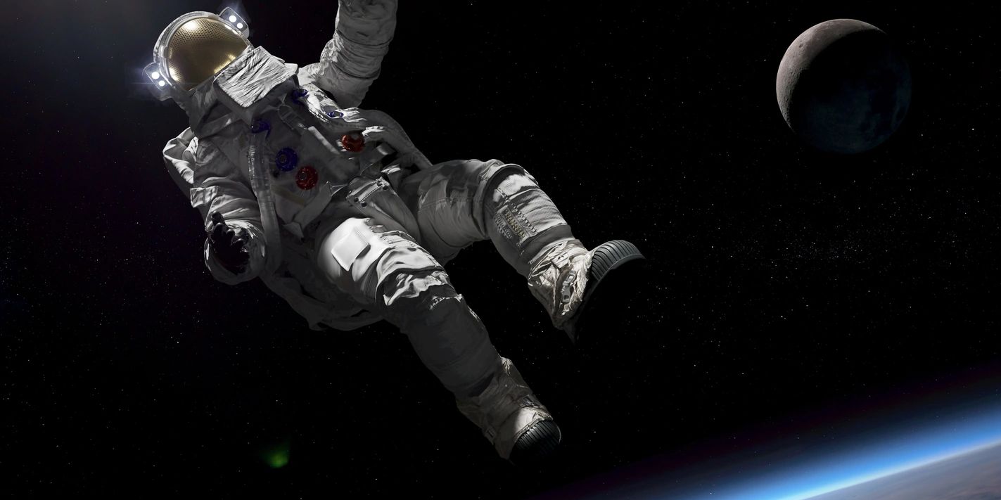 Astronaut floating in space near Earth and the Moon.