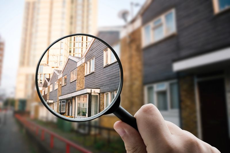 Social housing building facade, emphasized through a magnifying glass to highlight affordable housing and urban planning.