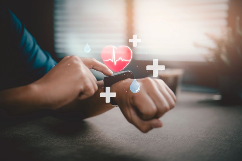 Person using smartwatch displaying heart rate and health monitoring icons indoors.