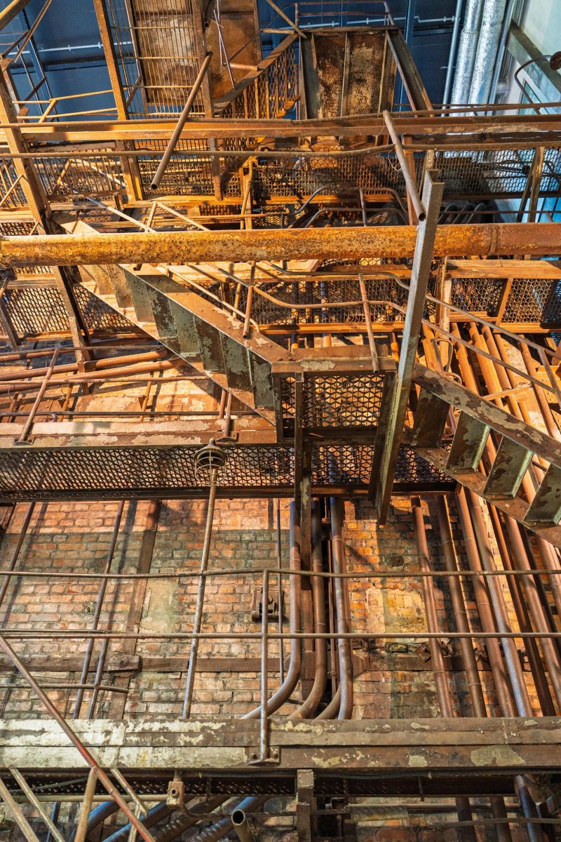Discover the beauty of industrial design in this image featuring rusted metal stairs and pipes. The striking composition highlights a unique blend of decay and history, perfect for backgrounds.