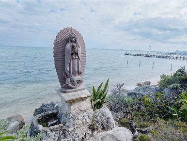 Estatua religiosa junto al mar.